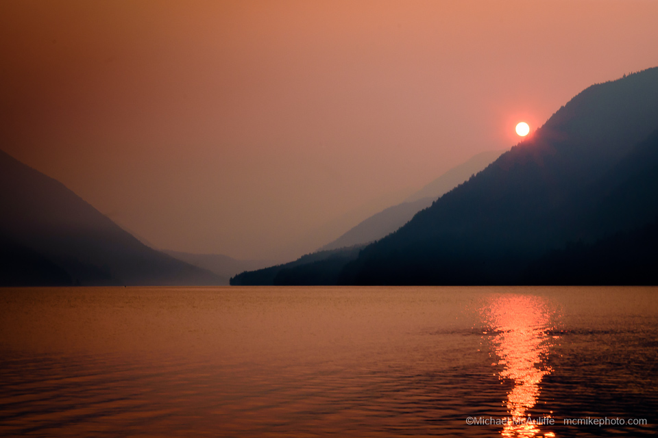 A smoky orange sunset over Lake Crescent in Olympic National Park.
